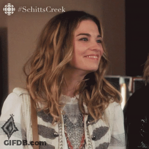 Woman Smiling In Front Of #Schittscreek Ad GIF
