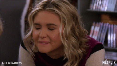 Woman Smiling In Front Of Netflix Shelf GIF