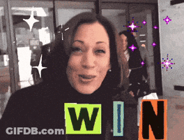 A Woman Is Smiling In Front Of A Sign That Reads Win GIF