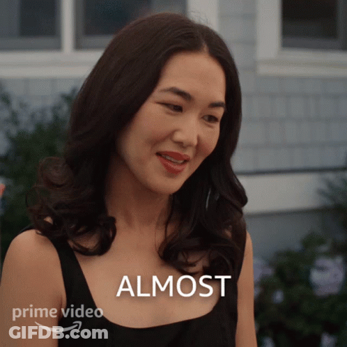 A Woman Is Smiling In Front Of A Sign That Says Almost On It GIF