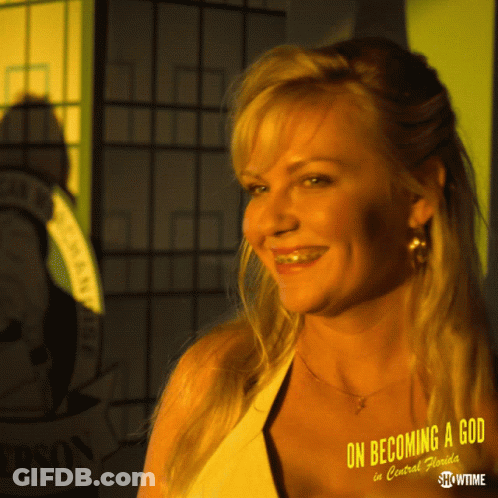 A Woman Is Smiling In Front Of A Sign That Says On Becoming A God In Central Florida GIF