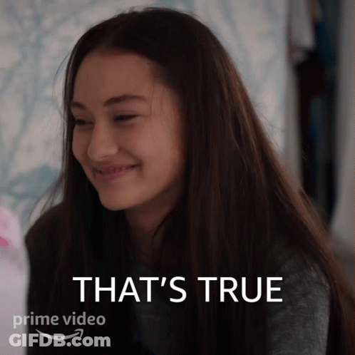 A Woman Is Smiling In Front Of A Sign That Says That 'S True On It GIF