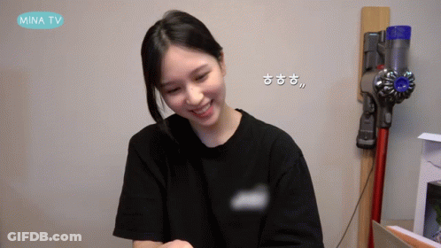 A Woman Is Smiling In Front Of A Vacuum Cleaner That Says Mina Tv On The Bottom GIF