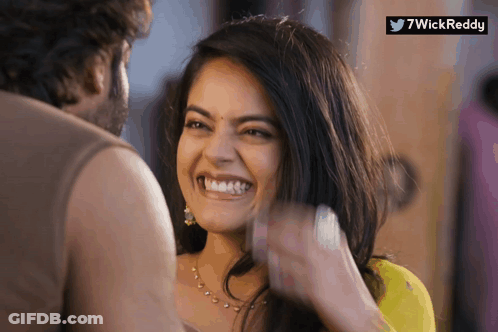 A Woman Is Smiling While A Man Looks On And A Twitter Logo Is Visible GIF