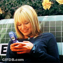 A Woman Is Smiling While Holding A Blue Cell Phone GIF