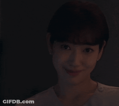 A Woman Is Smiling While Holding A Knife With A Purple Light On It GIF