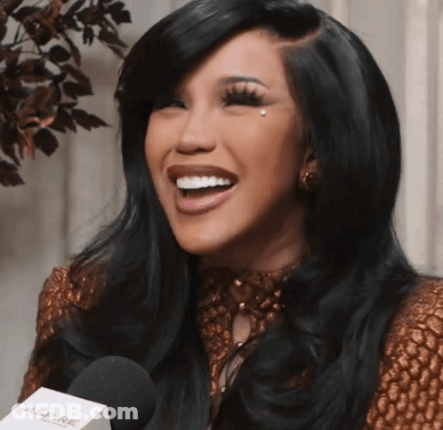 A Woman Is Smiling While Holding A Microphone That Says Aspire GIF