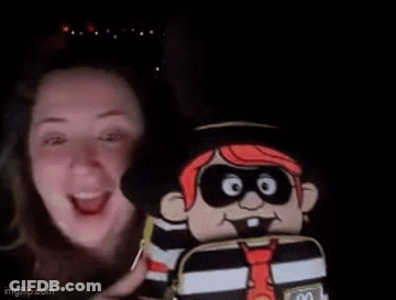 A Woman Is Smiling While Holding A Stuffed Pirate Doll . GIF