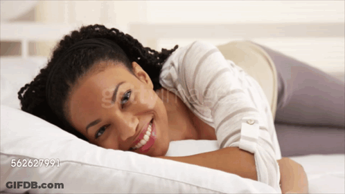 A Woman Is Smiling While Laying On A Bed With The Number 562627991 On The Bottom GIF