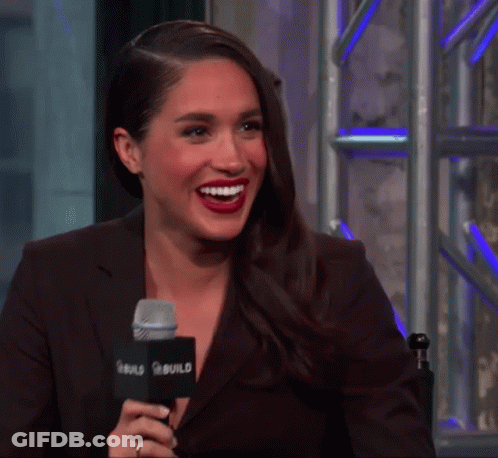 A Woman Is Smiling While Talking Into A Microphone That Says Build On It GIF