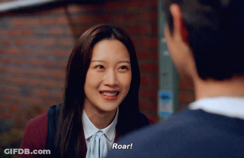 A Woman Is Smiling While Talking To A Man And Says Roar GIF