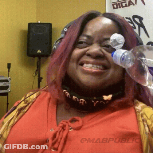 A Woman Is Smiling With A Bottle Of Water In Front Of Her Face GIF