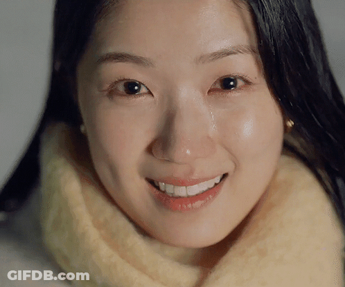 A Woman Is Smiling With A Tear Running Down Her Cheek GIF
