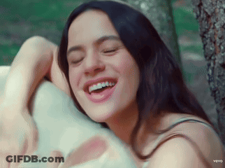 A Woman Is Smiling With Her Eyes Closed And Her Teeth Showing GIF