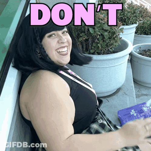 A Woman Is Smiling With The Word Don 'T In Pink Letters GIF