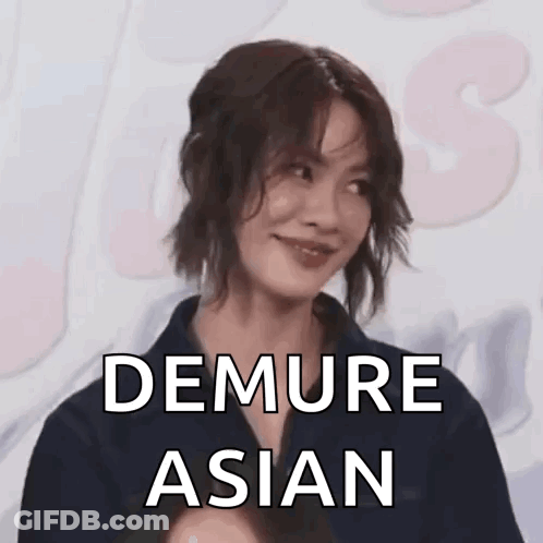 A Woman Is Smiling With The Words `` Demure Asian '' Written Above Her . GIF