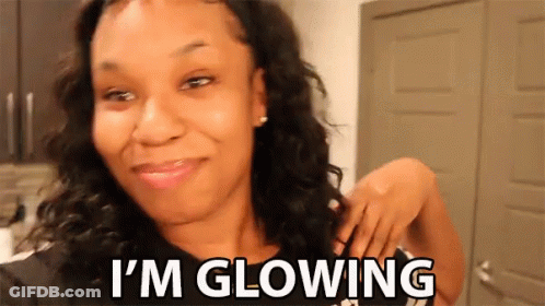 A Woman Is Smiling With The Words I 'M Glowing Below Her GIF