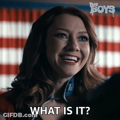 A Woman Is Smiling With The Words What Is It Behind Her GIF
