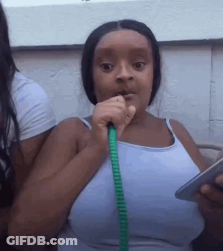 A Woman Is Smoking A Hookah While Holding A Cell Phone GIF