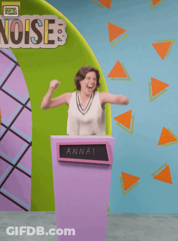 A Woman Is Standing Behind A Podium With The Name Anna On It GIF