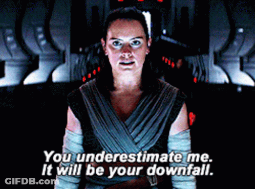 A Woman Is Standing In A Dark Room And Saying You Underestimate Me It Will Be Your Downfall GIF