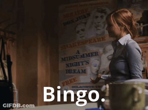 A Woman Is Standing In A Dark Room And The Word Bingo Is On The Screen GIF