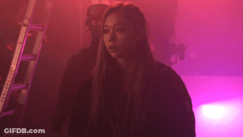 A Woman Is Standing In A Dark Room With Purple Lights And The Words Gifsaespa On The Bottom GIF