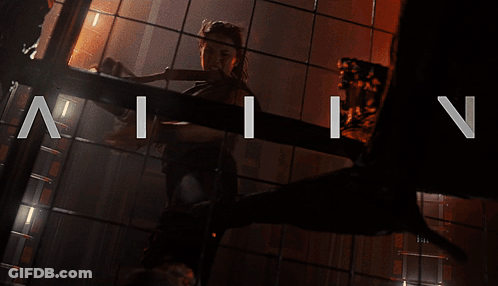 A Woman Is Standing In A Dark Room With The Letters N And I On The Bottom GIF