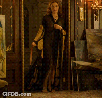 A Woman Is Standing In A Doorway With A Clock On The Wall That Says ' Clock ' On It GIF
