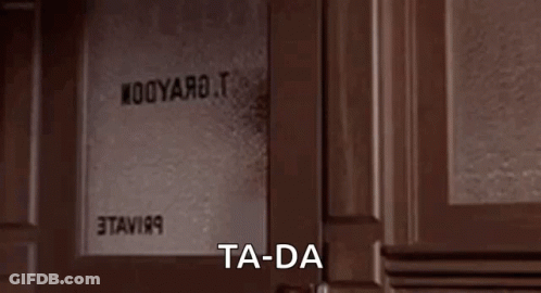 A Woman Is Standing In A Doorway With The Words `` Ta-Da '' Written On The Screen . GIF