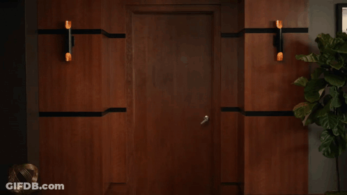 A Woman Is Standing In A Hallway With A Sign That Says Mst On It GIF