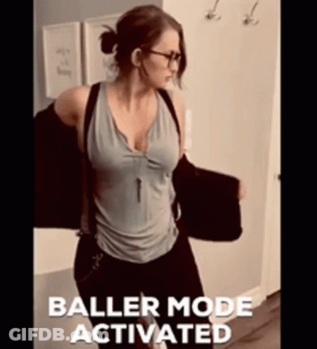 A Woman Is Standing In A Hallway With The Words Baller Mode Activated On The Bottom Right GIF