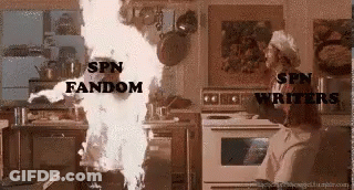 A Woman Is Standing In A Kitchen Next To A Fire That Is Coming Out Of The Oven . GIF