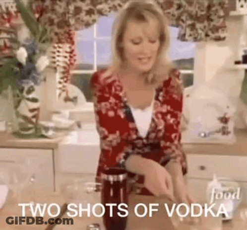 A Woman Is Standing In A Kitchen Preparing A Drink And Says `` Two Shots Of Vodka '' . GIF