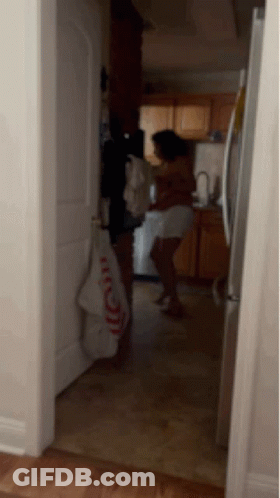 A Woman Is Standing In A Kitchen With A Towel That Says ' I Love You ' On It GIF