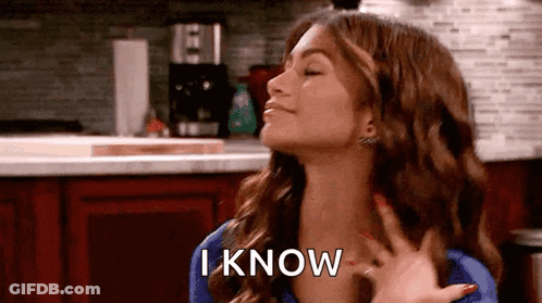 A Woman Is Standing In A Kitchen With Her Eyes Closed And Her Hand On Her Chest And The Words `` I Know '' . GIF