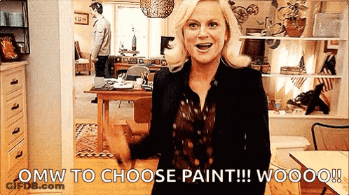 A Woman Is Standing In A Living Room With The Words `` Omw To Choose Paint !!! Wooo ! '' GIF