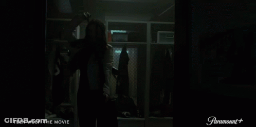 A Woman Is Standing In A Locker Room With The Words Teen Wolf The Movie On The Bottom GIF