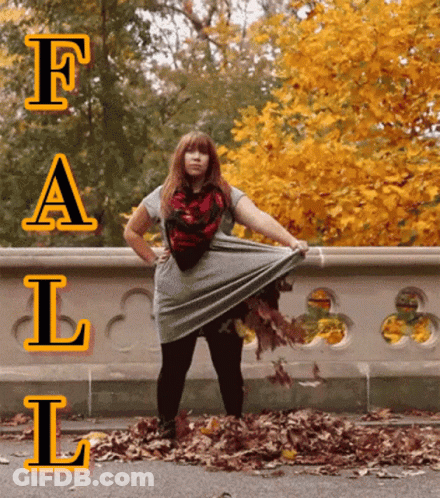 A Woman Is Standing In A Pile Of Leaves With The Word Fall Behind Her GIF