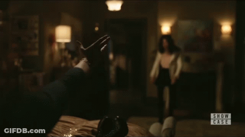 A Woman Is Standing In A Room With A Sign That Says Show Case On It GIF