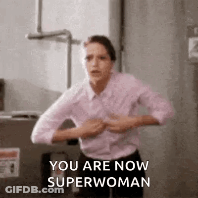A Woman Is Standing In A Room With Her Hands On Her Chest . GIF
