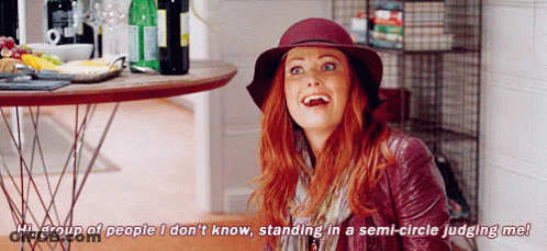 A Woman Is Standing In A Semi-Circle Judging Another Woman . GIF
