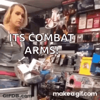 A Woman Is Standing In A Store Holding A Bag Of Groceries And A Sign That Says `` Its Combat Arms '' . GIF