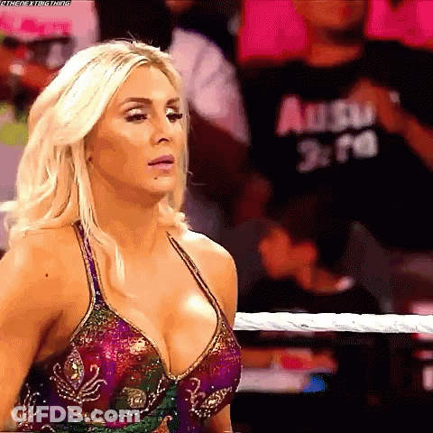A Woman Is Standing In A Wrestling Ring Wearing A Very Revealing Dress . GIF