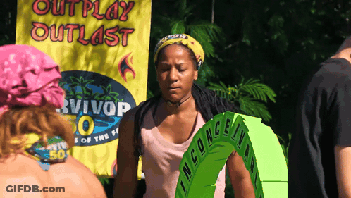 A Woman Is Standing In Front Of A Banner That Says Outplay Outlast GIF