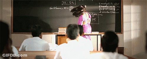 A Woman Is Standing In Front Of A Blackboard That Says R.v. R.h. On It GIF