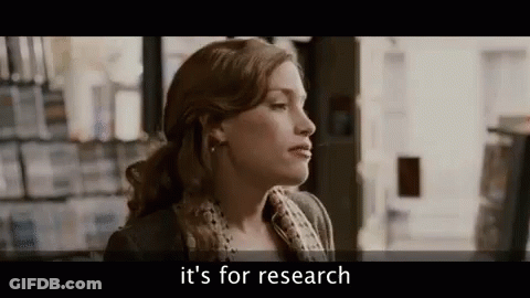 A Woman Is Standing In Front Of A Bookshelf In A Bookstore And Talking About Research . GIF