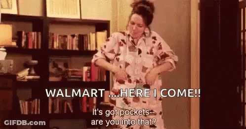 A Woman Is Standing In Front Of A Bookshelf In A Living Room . GIF