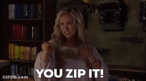 A Woman Is Standing In Front Of A Bookshelf With A Fist In The Air And Saying `` You Zip It ! '' GIF