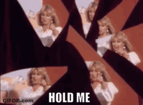 A Woman Is Standing In Front Of A Broken Mirror . GIF